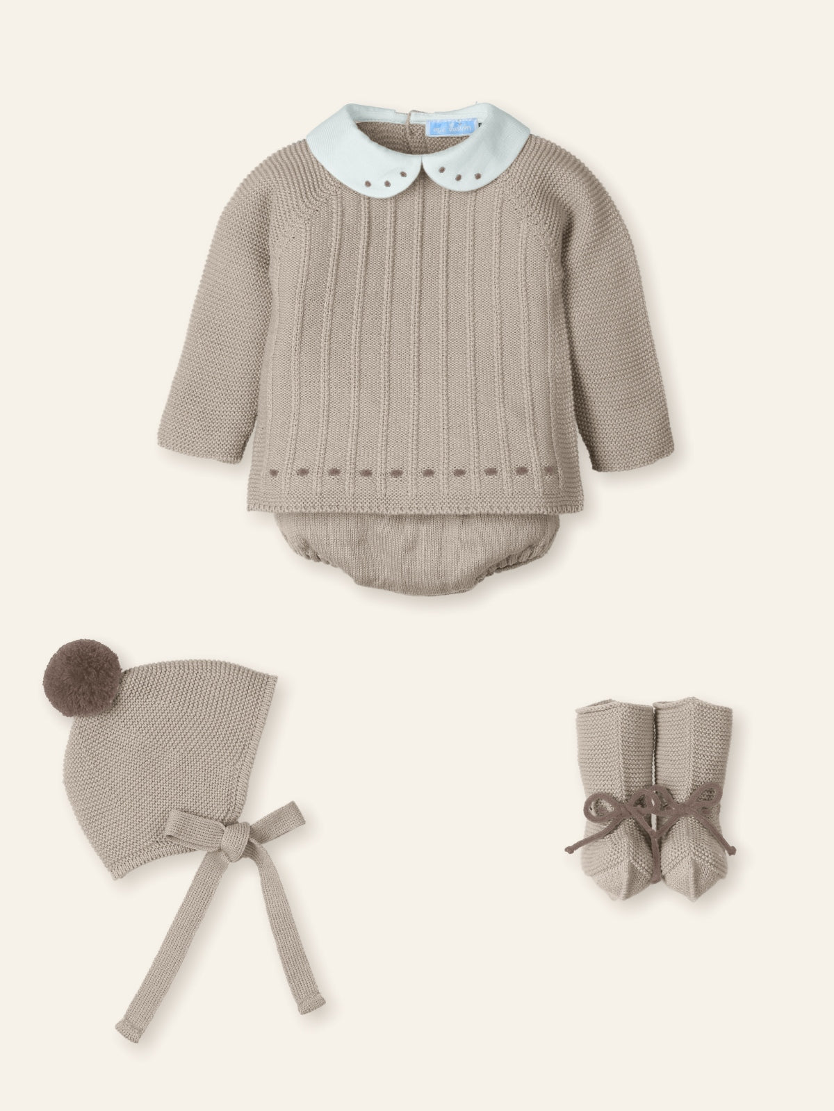 Baby outfit set with knitted romper, bonnet, and booties on a white background