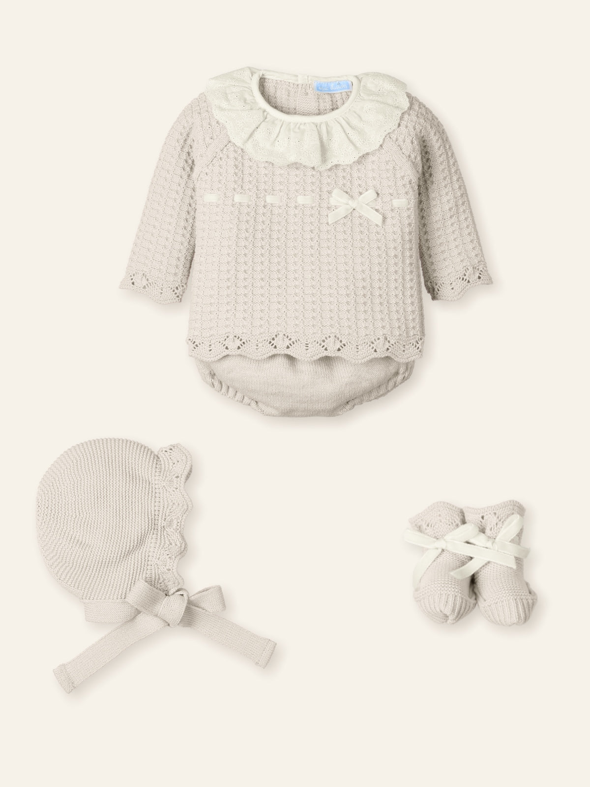 Baby outfit set with long-sleeve top, bonnet, and mittens on a white background
