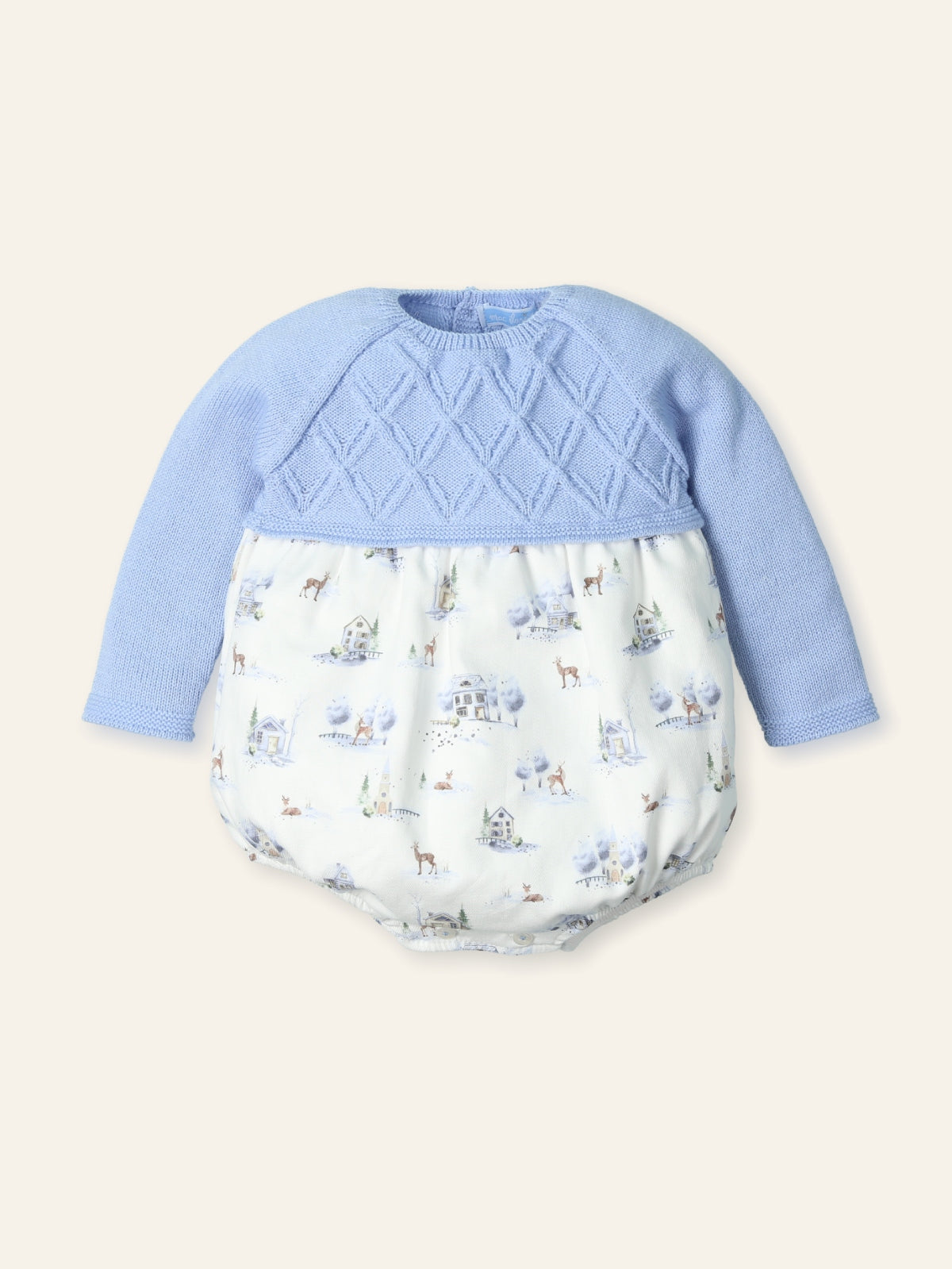 Baby outfit with blue top and patterned bottom on a beige background