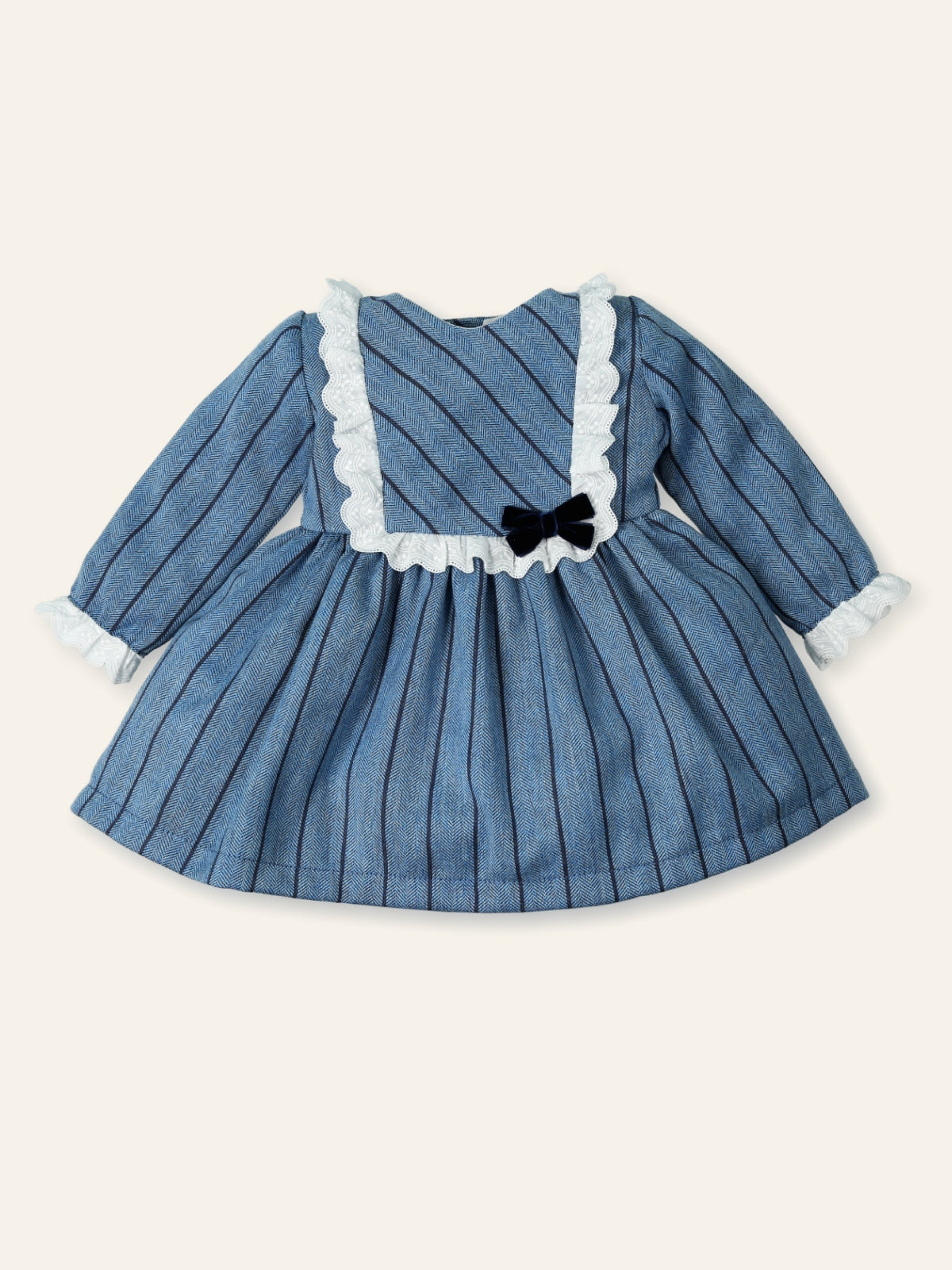Blue dress with white ruffled collar and black bow on a beige background