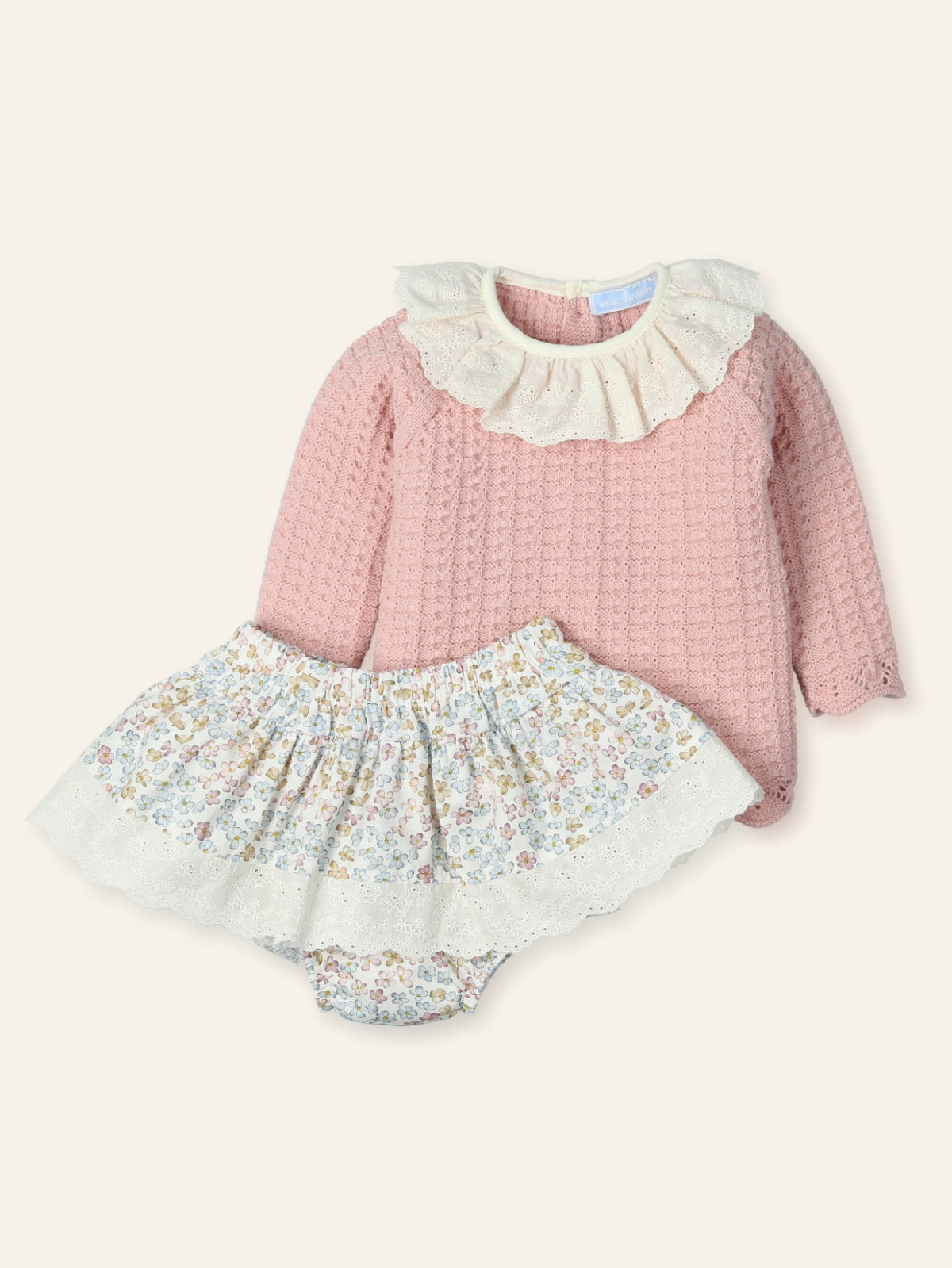 Pink long-sleeve top and floral skirt set on a white background