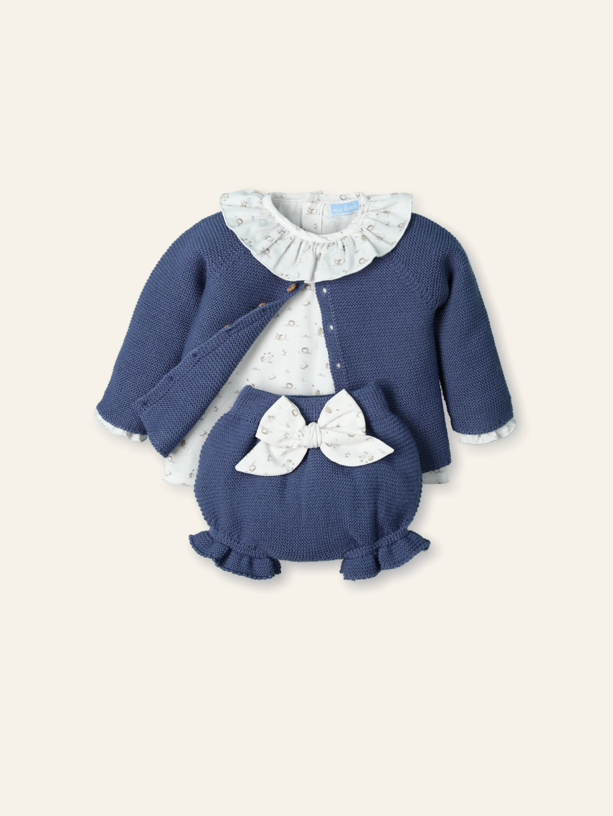 Children's blue sweater set with white ruffled collar and bow on a light beige background
