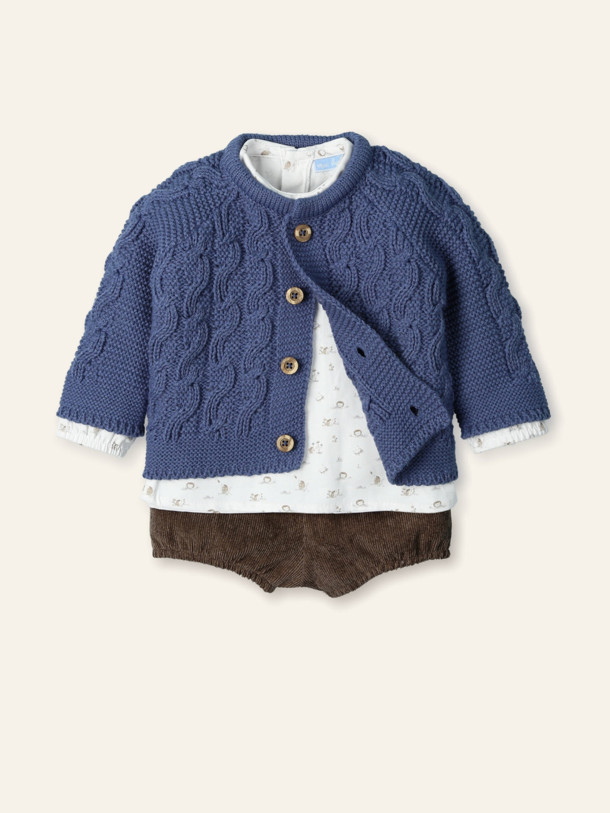 Blue knitted cardigan over a white shirt with brown shorts on a beige background