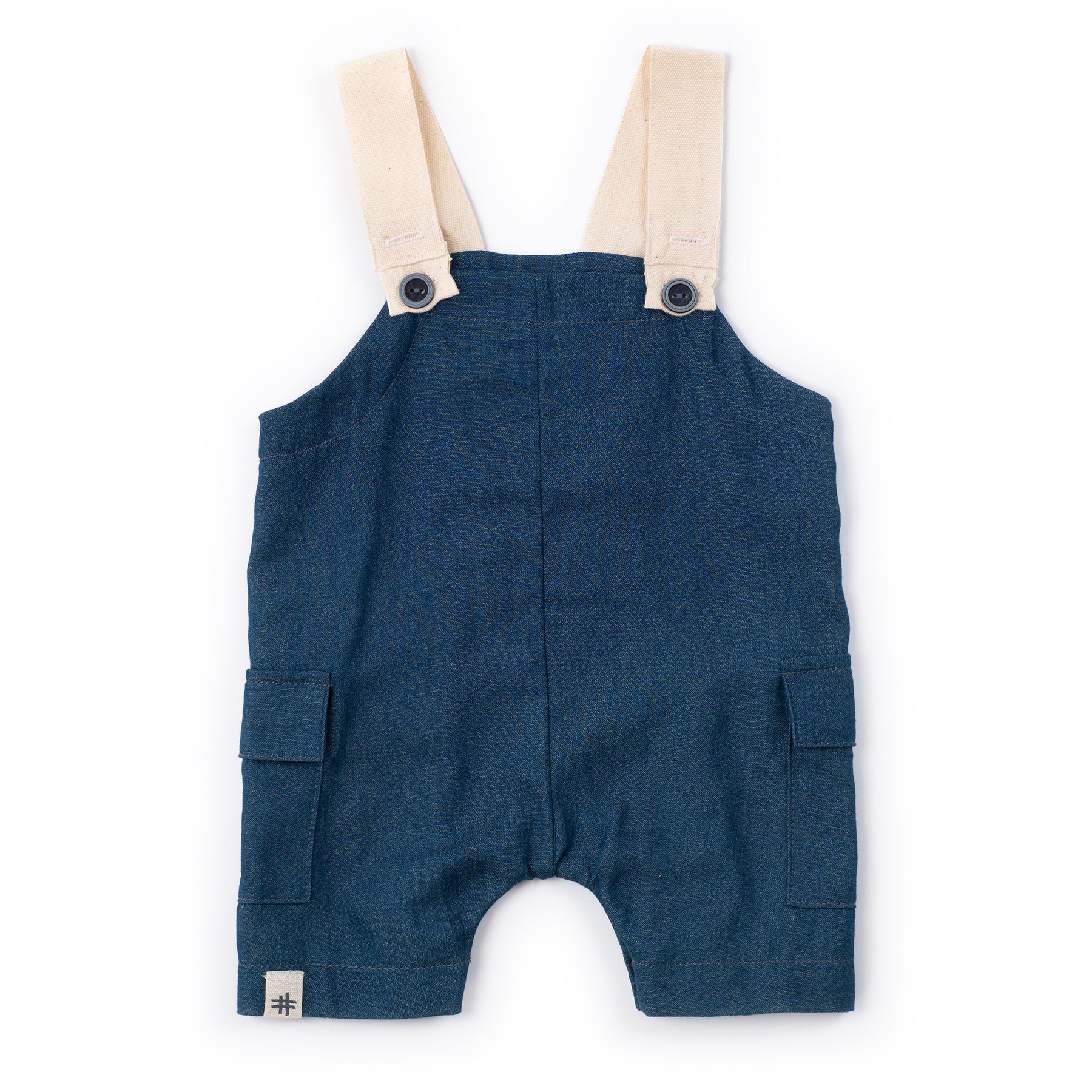 Blue denim overalls with beige straps on a white background