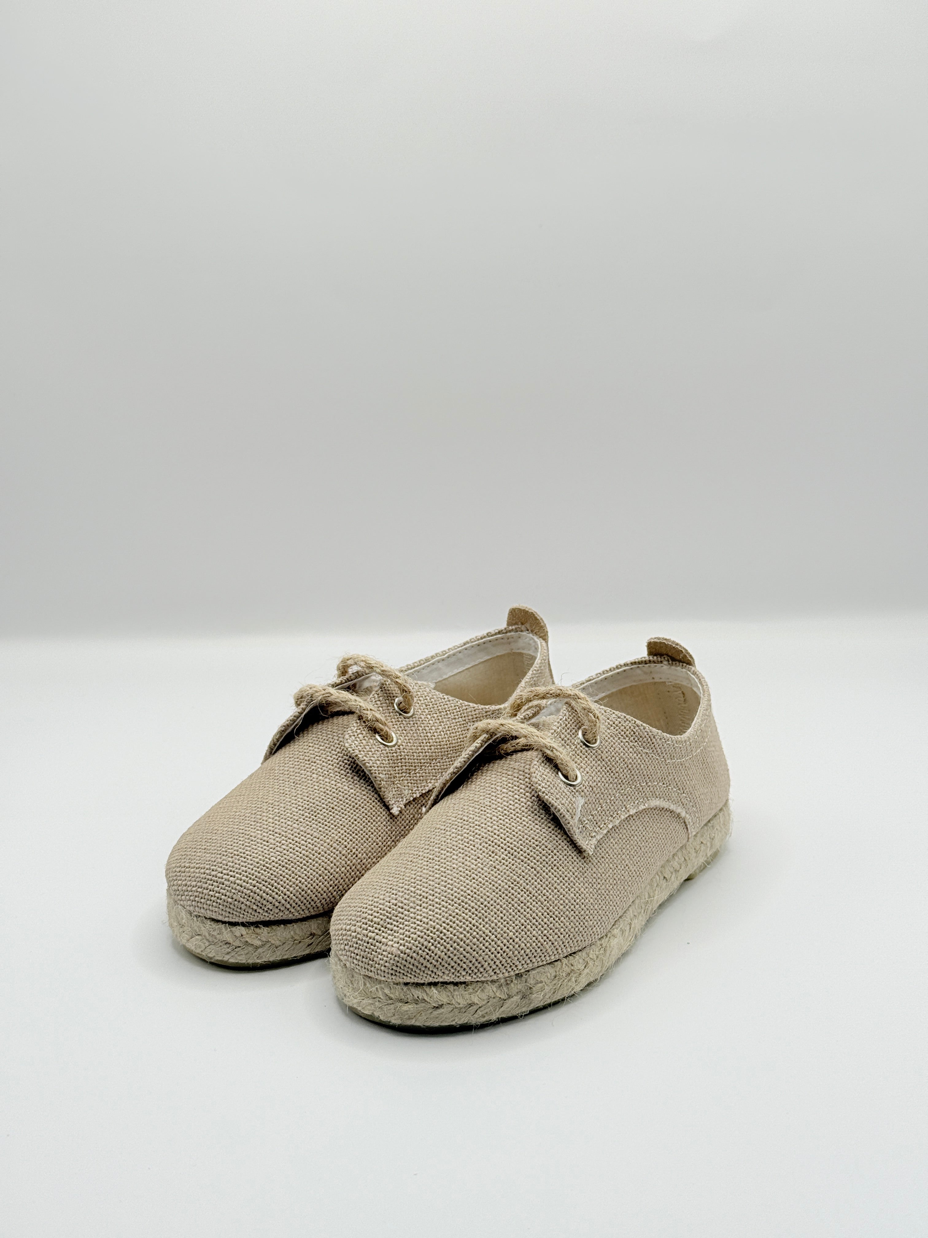 Pair of beige baby shoes on a white background
