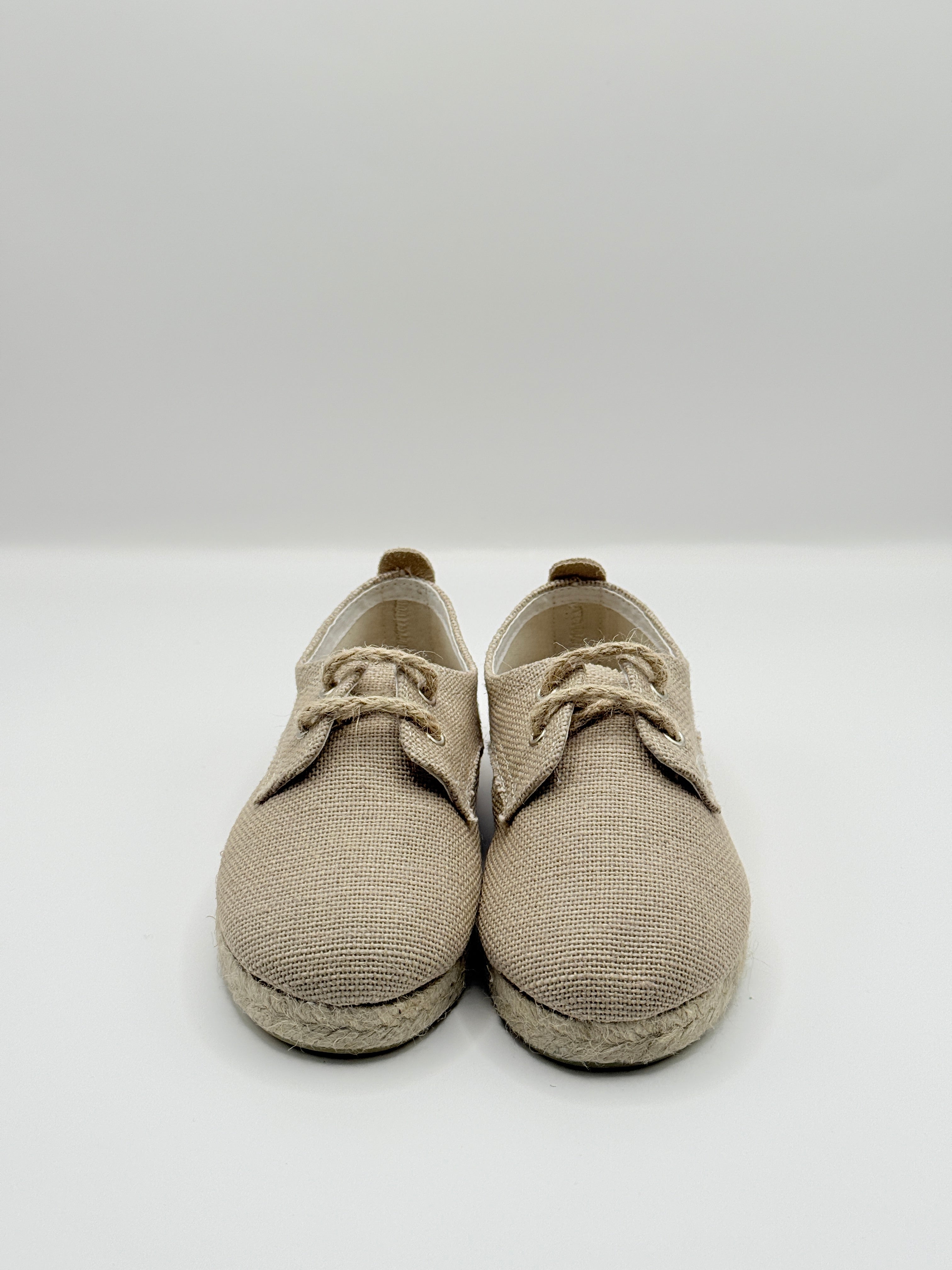 Pair of beige baby shoes on a white background
