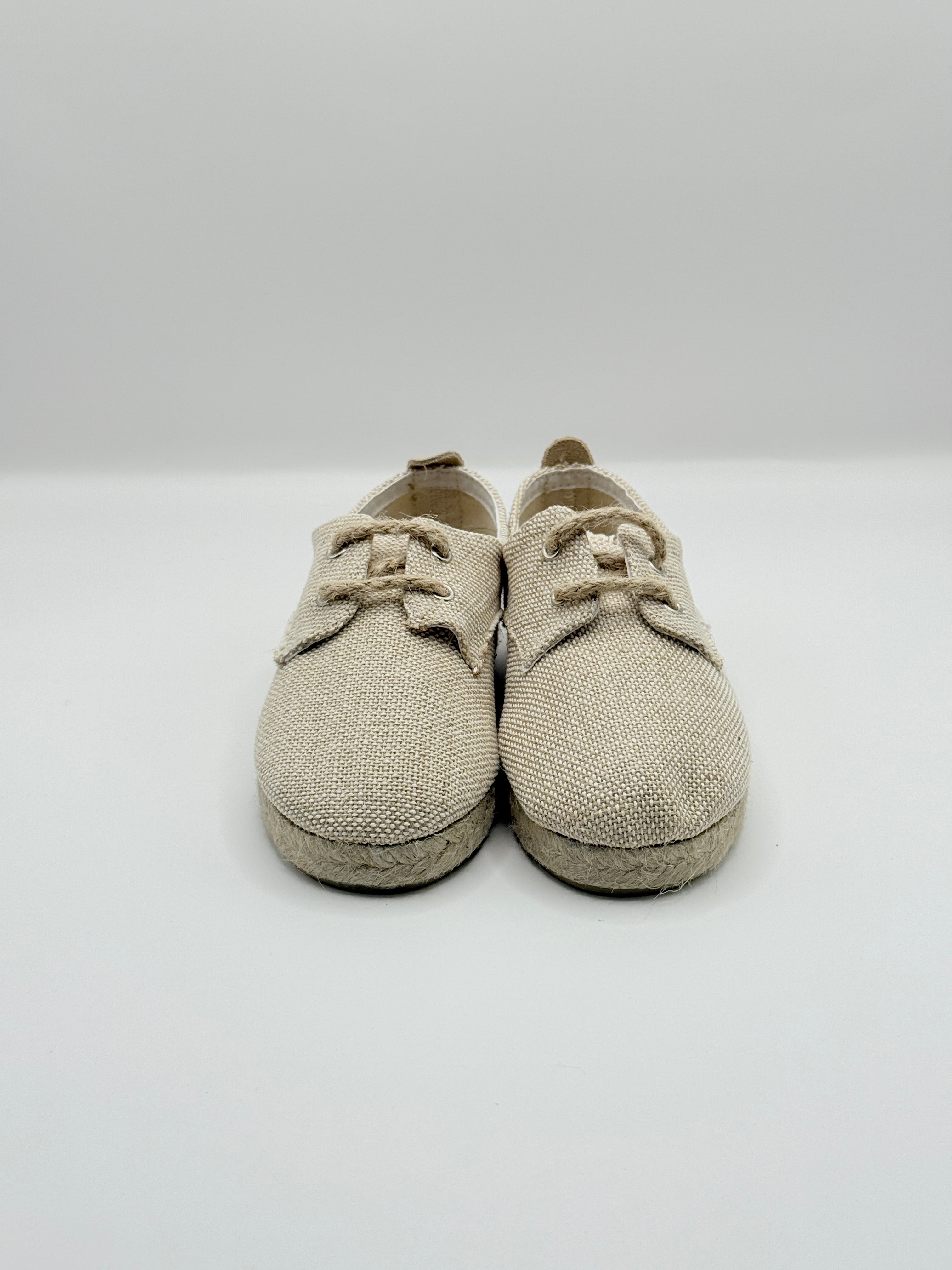 Pair of beige baby shoes on a white background