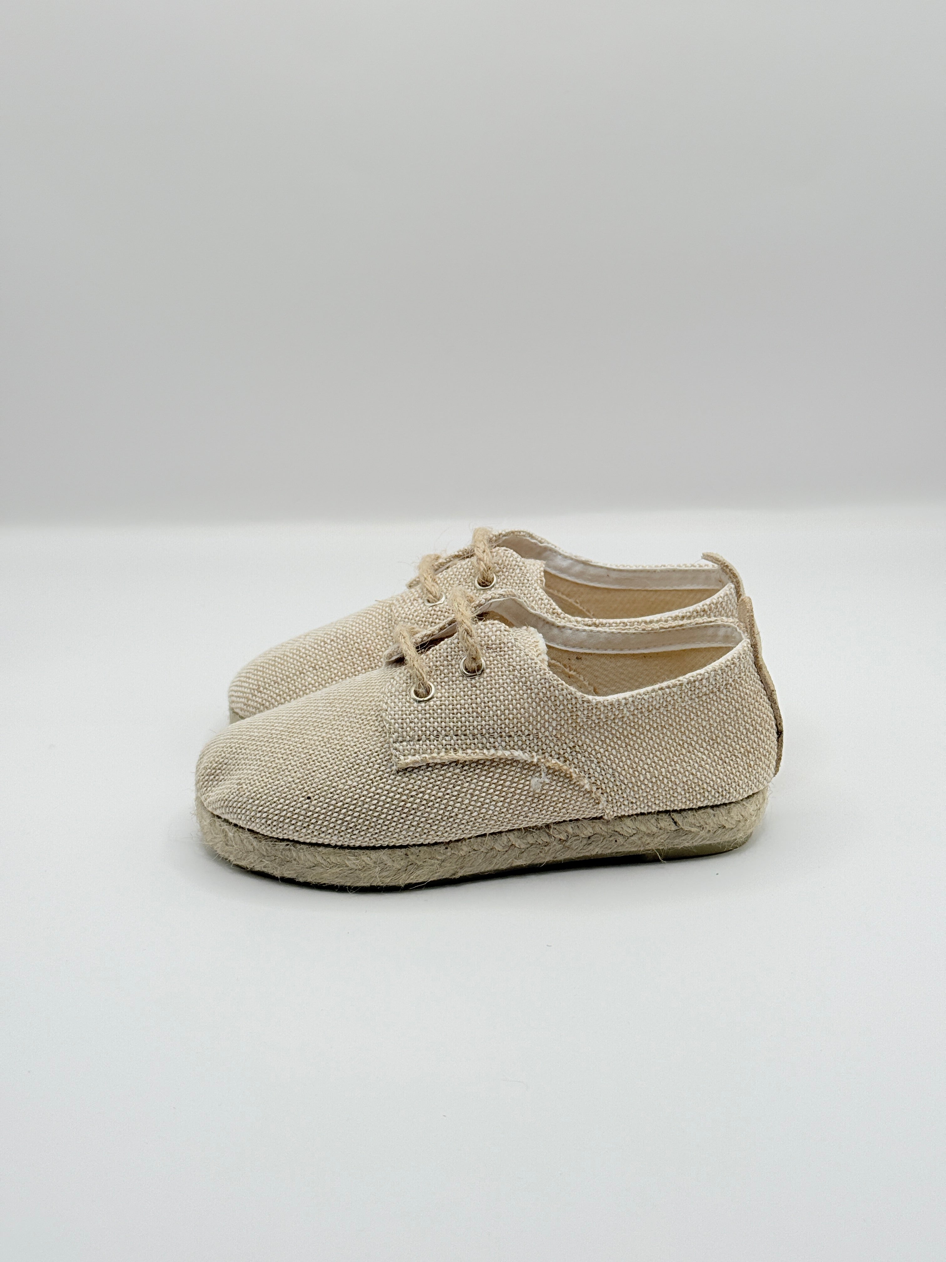 Pair of beige slip-on shoes on a white background