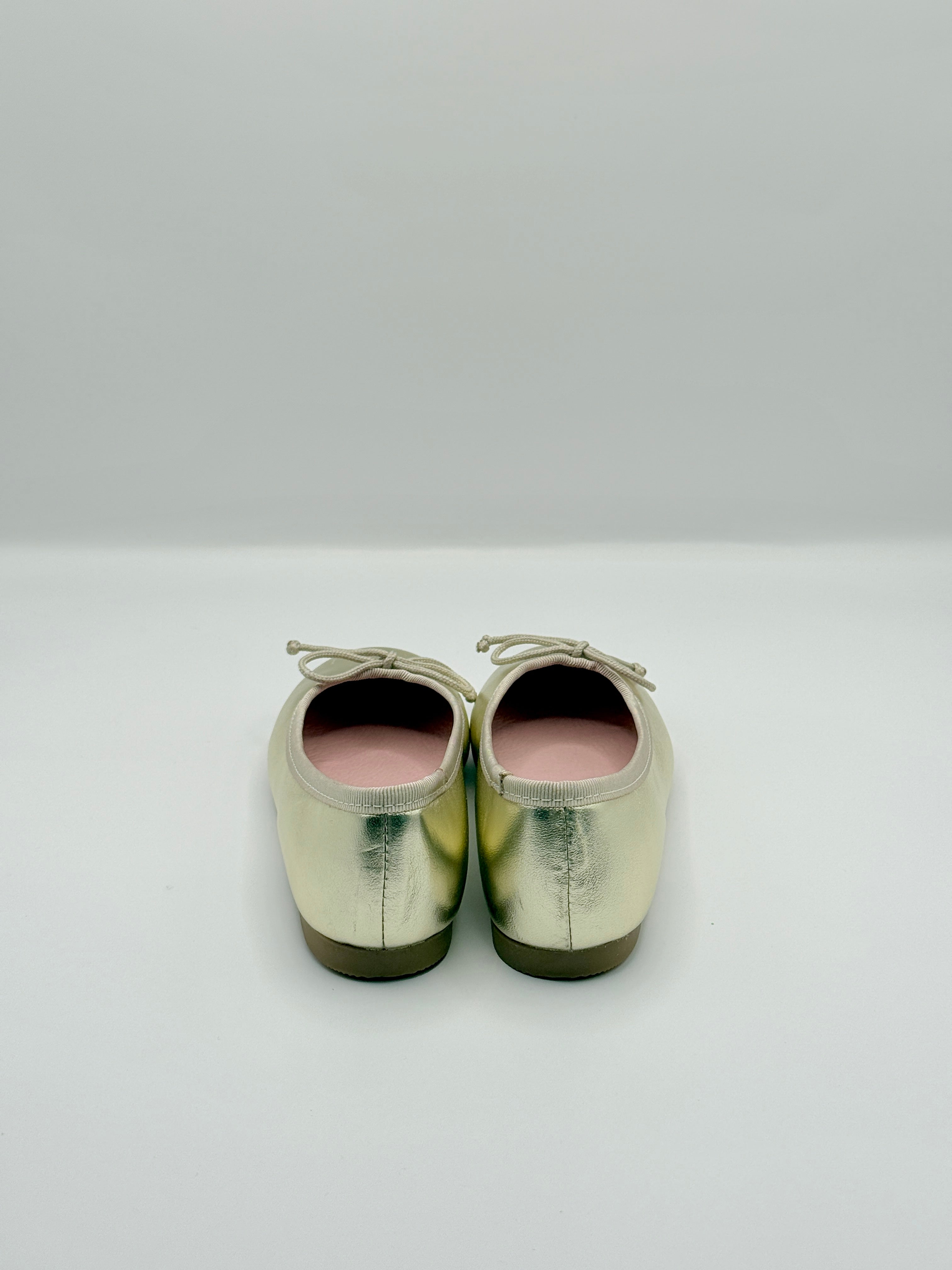 Pair of metallic green shoes on a white background