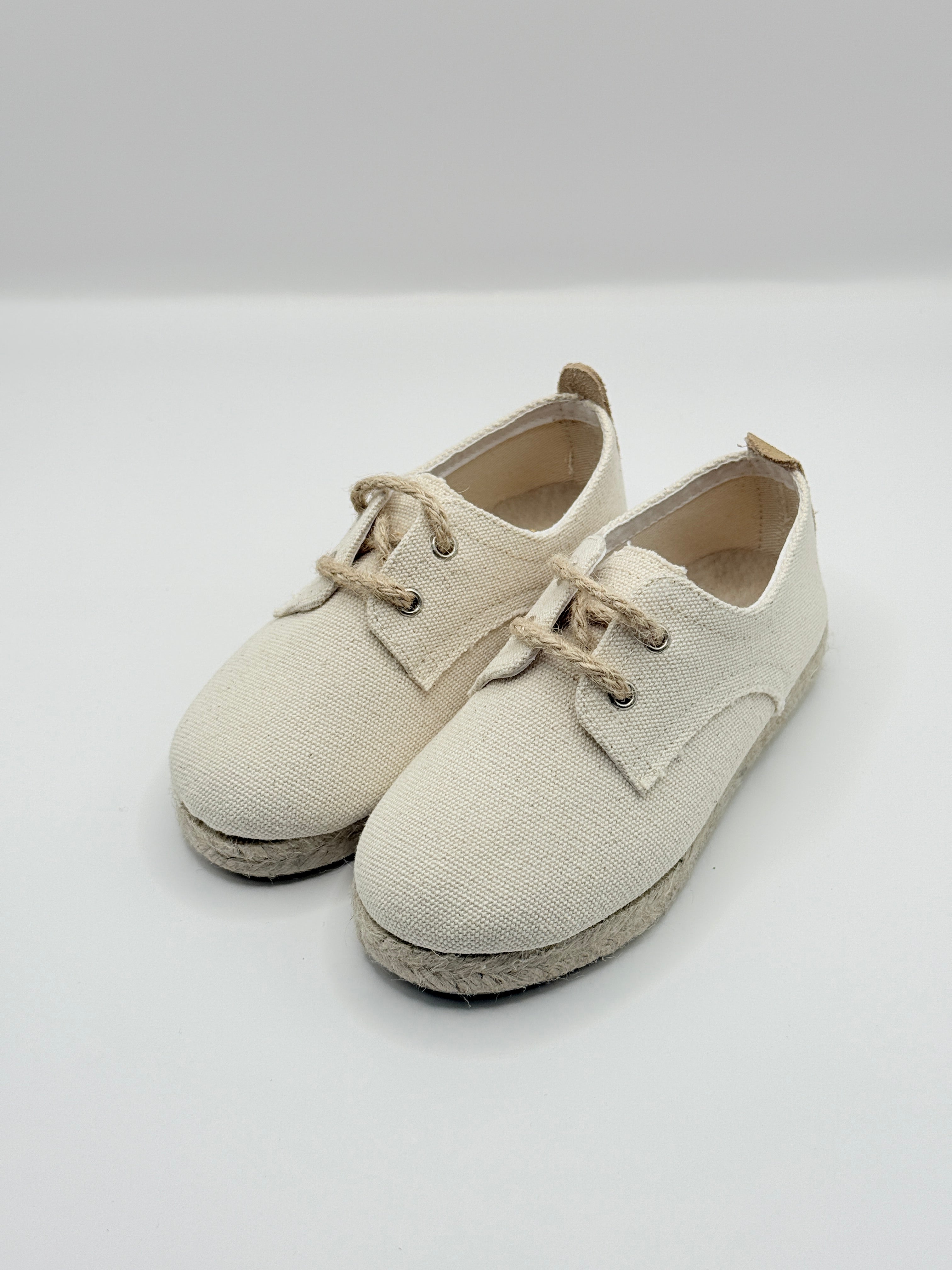 Pair of beige baby shoes on a light gray background