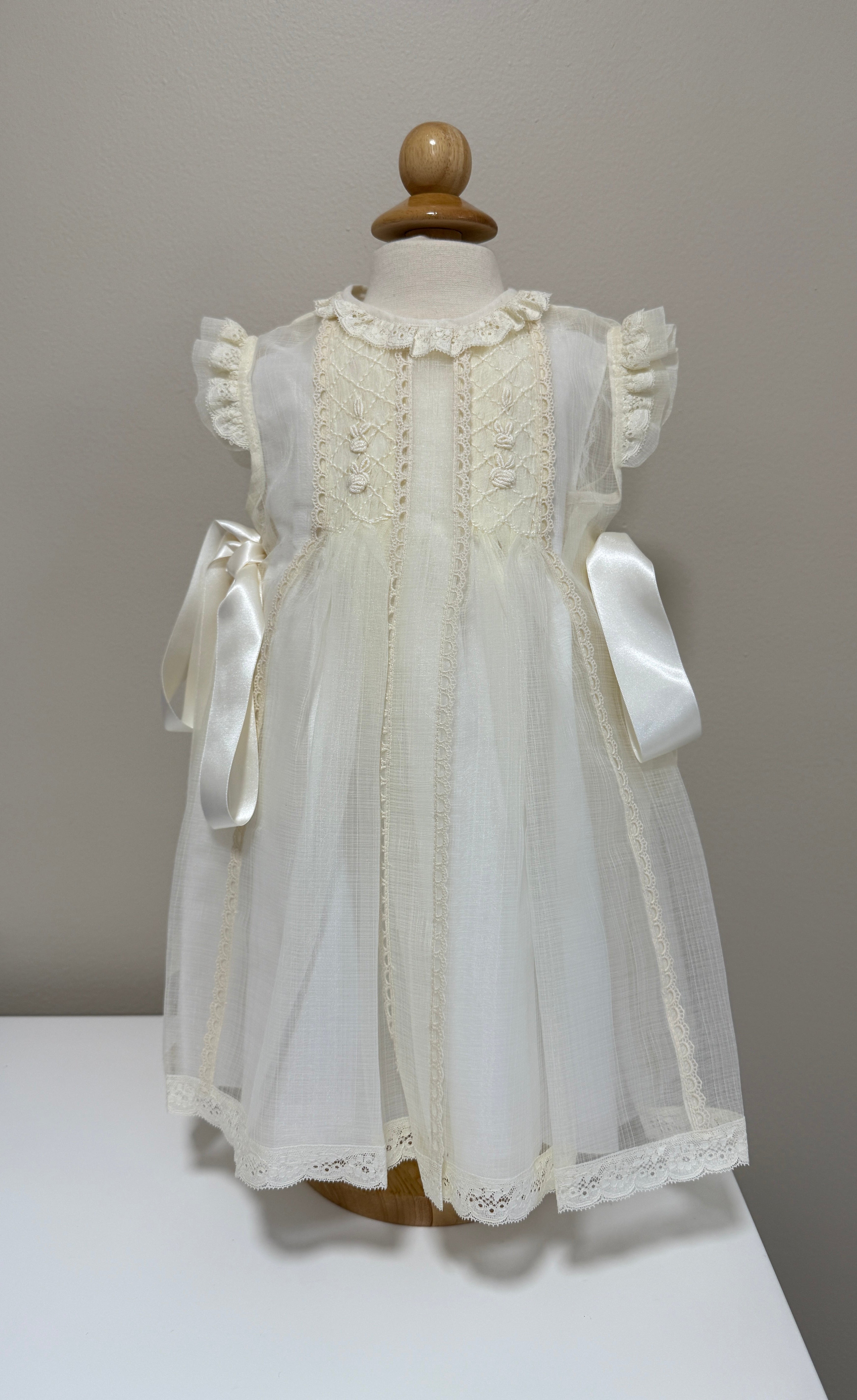 White lace dress on a mannequin against a plain background