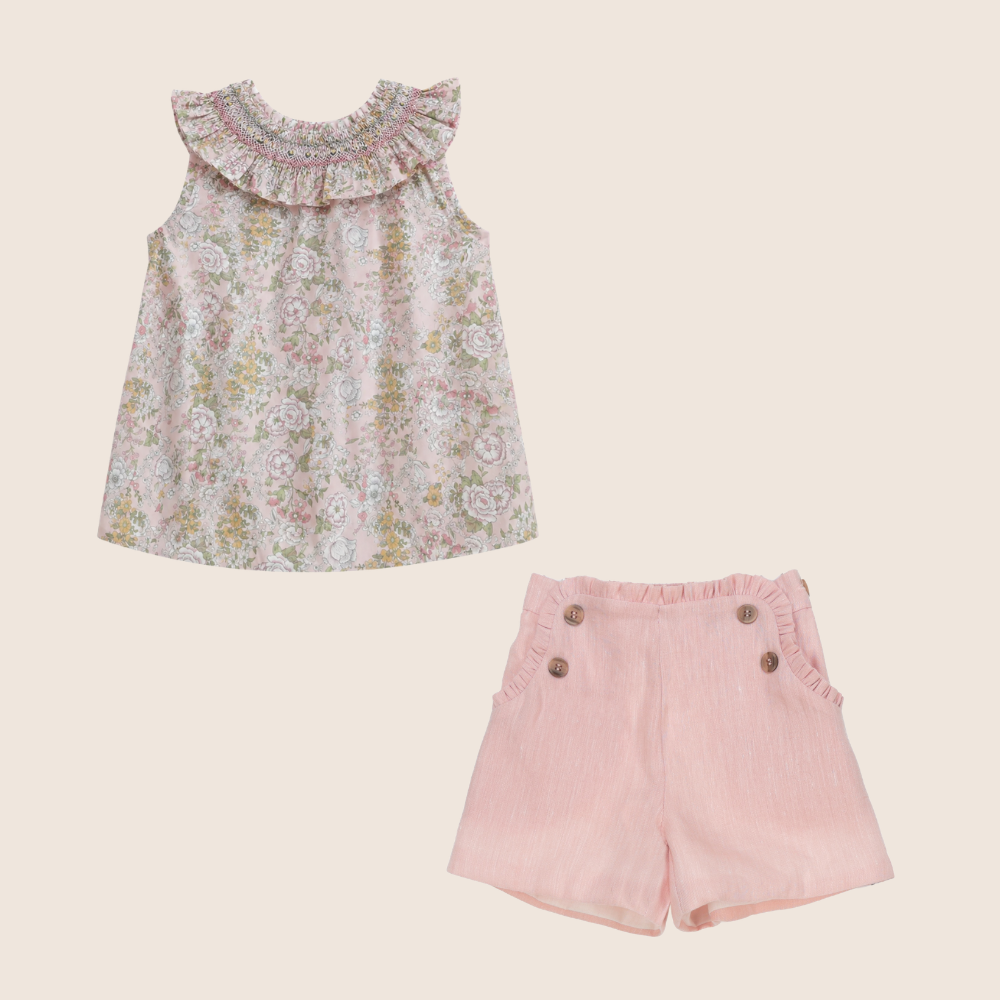 Floral top and pink shorts set on a beige background
