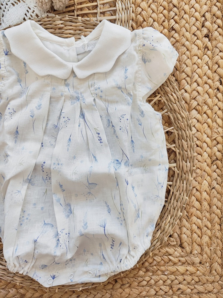 Baby romper with floral pattern on a woven surface