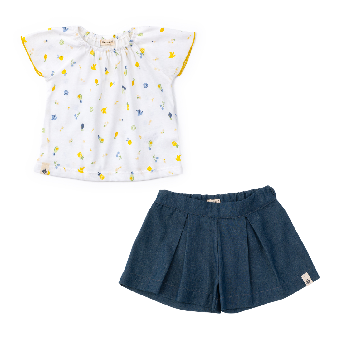 White blouse with colorful patterns and blue shorts on a white background