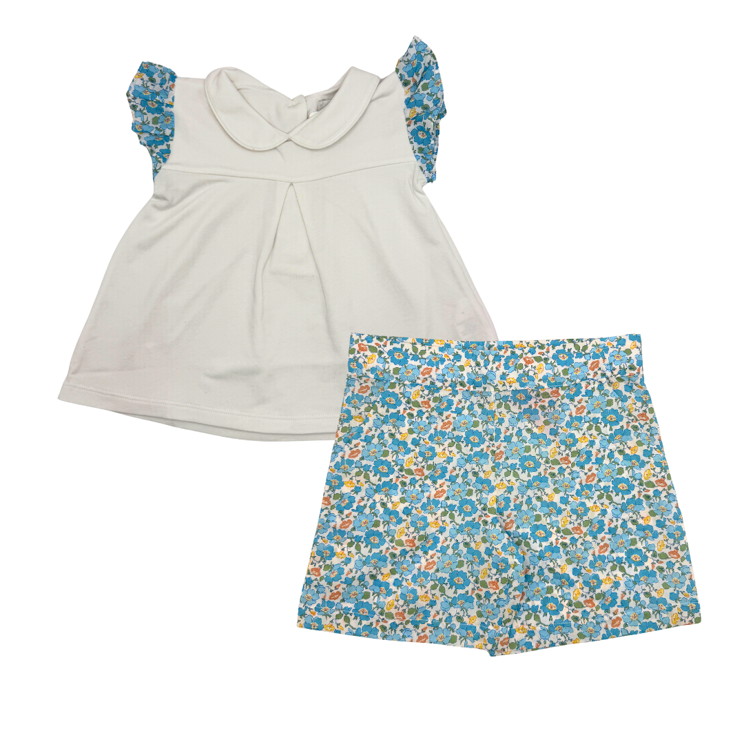 White top with floral sleeves and a blue floral skirt on a white background