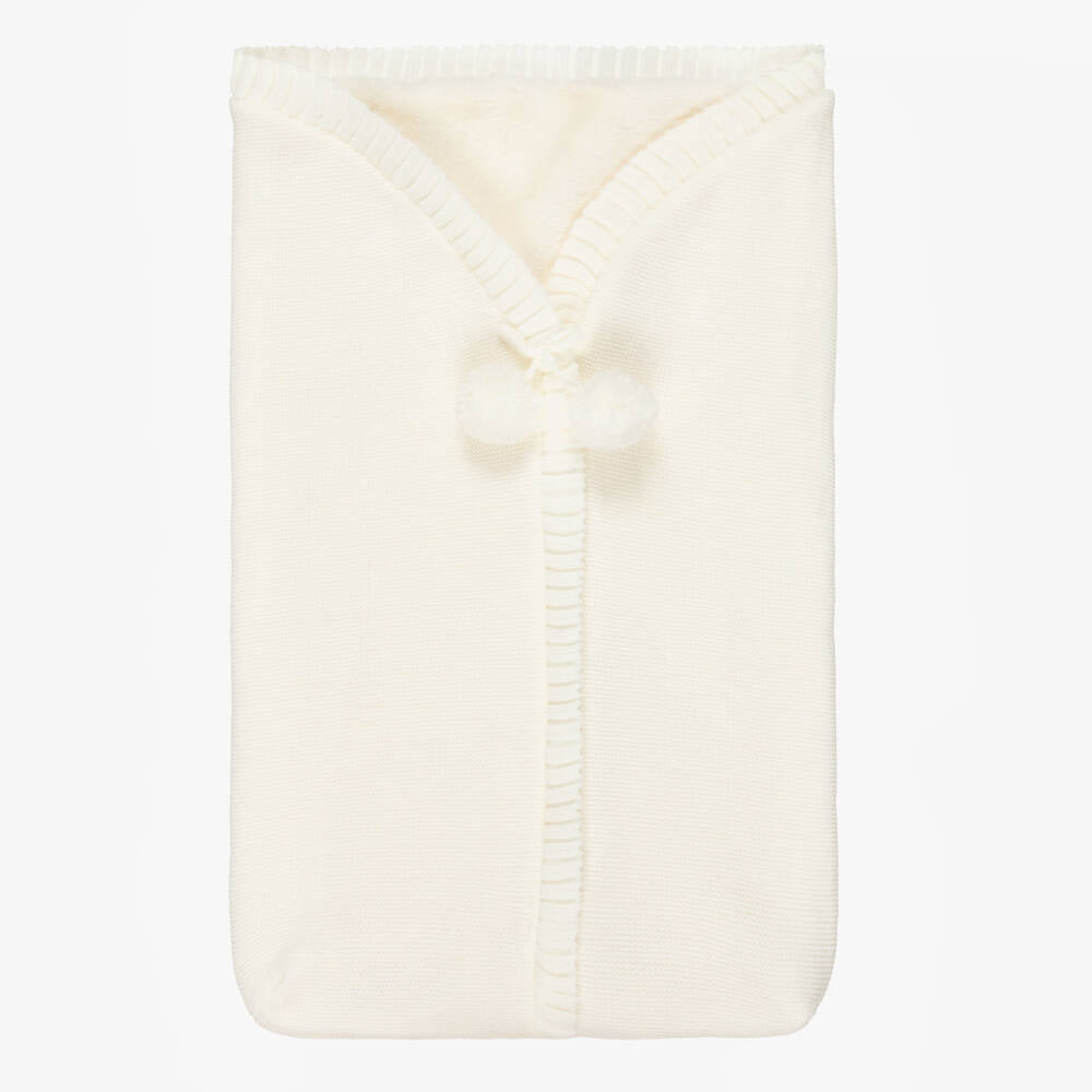 Folded cream-colored blanket on a white background