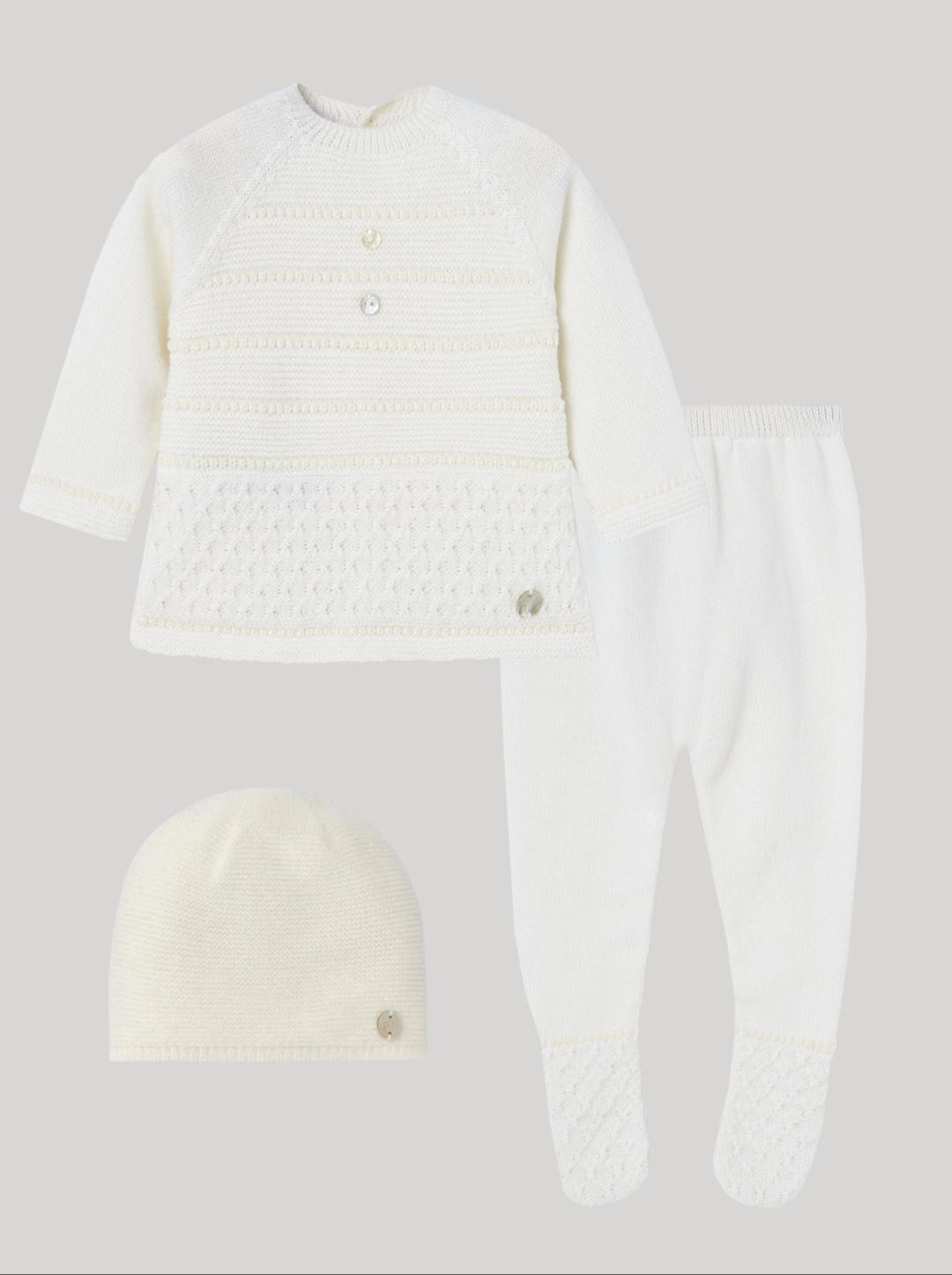 White sweater, pants, and beanie set on a light gray background